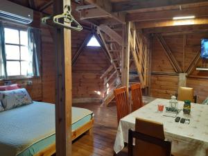 una habitación con una mesa y una cama en una cabaña en בקתת עץ בחורש במנות - דום גיאודזי - Wooden cabin in Manot, en Manot