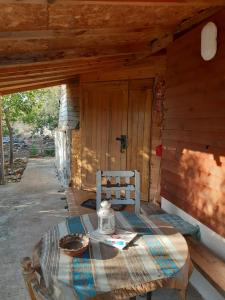 una mesa en la parte trasera de una cabaña de madera en בקתת עץ בחורש במנות - דום גיאודזי - Wooden cabin in Manot en Manot