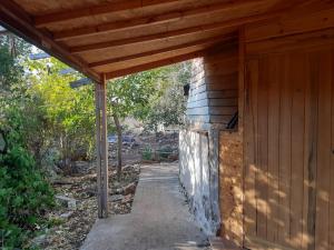ein Holzgebäude mit einem Holzdach in der Unterkunft בקתת עץ בחורש במנות - דום גיאודזי - Wooden cabin in Manot in Manot