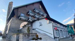 a building with a staircase leading up to it at Vila Ursul Negru in Sovata