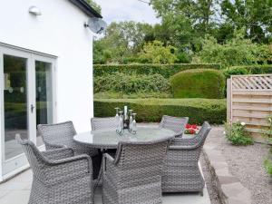 a patio with a table and wicker chairs at The Old Chapel in Grosmont