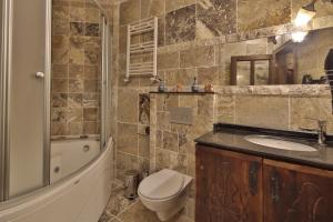 a bathroom with a toilet and a sink and a shower at Old Town Stone House in Göreme