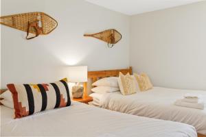 two beds in a room with white walls at Lovely 3 Bedroom Wintergreen Retreat w Sauna in Blue Mountains