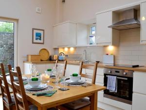 eine Küche mit einem Holztisch mit Stühlen und einem Esszimmer in der Unterkunft Birch Tree Cottage in Edzell