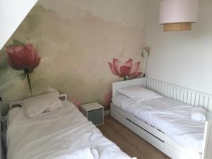 twee bedden in een kamer met bloemen aan de muur bij Nouveau! Superbe appartement avec terrasse vue mer in Ambleteuse