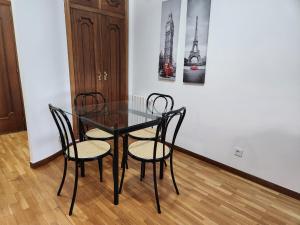 una mesa de comedor negra con 2 sillas y una foto en Estudio con vistas a la ciudad, en Ourense
