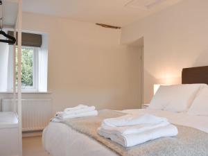 a white bedroom with white towels on a bed at Thistle Cottage in Carlton