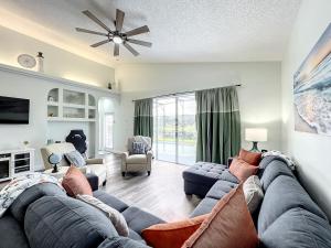 a living room with a couch and a tv at Glenbrook Pool Lake Home in Orlando