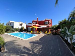 a swimming pool in front of a house at Sunshine Villa with Heated Pool in Faro