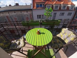 a green table and chairs on a balcony at Apartment Studio BOSSANOVA in Bydgoszcz