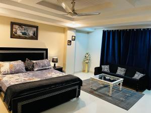 a bedroom with a bed and a couch at Entire 1 BR Apartment: Netflix, Youtube. in Islamabad