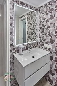 een badkamer met een witte wastafel en een spiegel bij Parrot's House- Yumbo center in Playa del Inglés