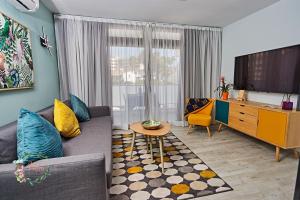 een woonkamer met een bank en een tv bij Parrot's House- Yumbo center in Playa del Inglés
