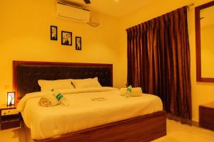 a bedroom with a large bed with towels on it at WESTN Resorts in Kuttālam