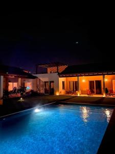 a swimming pool in front of a house at night at Casa da Courela in Cavaleiro
