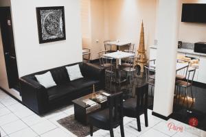 ein Wohnzimmer mit einer schwarzen Couch und einem Tisch in der Unterkunft Hotel Paris in Machala