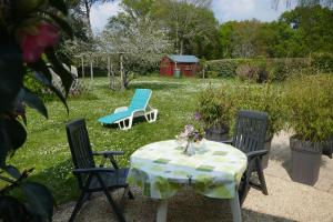 ラ・トリニテ・シュル・メールにあるgrand studio duplex avec jardinのテーブルとブランコ付きの庭のテーブルと椅子
