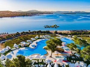 an airplane flies over a resort with a lake at Apartman Ivana in Šibenik