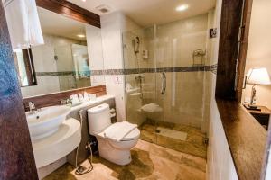 a bathroom with a toilet a sink and a bath tub at Goldenbell Hotel Chiangmai - SHA Extra Plus in Chiang Mai