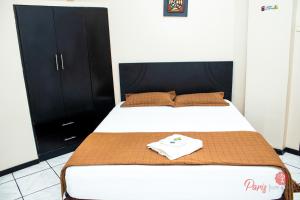 ein Bett mit einem weißen Hemd darüber in der Unterkunft Hotel Paris in Machala + 7 Fotos