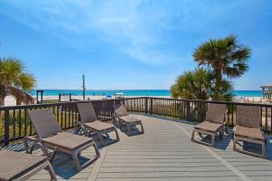 una terraza con sillas y la playa de fondo en Sunbird 1106W en Panama City Beach