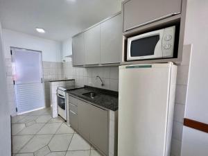 een keuken met een koelkast en een magnetron bij Sal De Mariscal 02 in Bombinhas