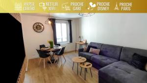 een woonkamer met een blauwe bank en een tafel bij Le Moulin Dort Hyper Centre Gare Disney in Meaux