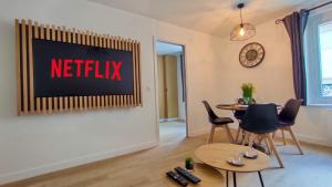 een woonkamer met een netflix-bord aan de muur bij Le Moulin Dort Hyper Centre Gare Disney in Meaux +18 foto's