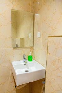 y baño con lavabo blanco y espejo. en WESTN Resorts en Kuttālam