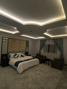 a hotel room with a large bed and a living room at قرين فيو in Abha
