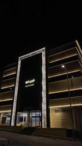 a building with a large sign on it at night at قرين فيو in Abha