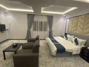 a hotel room with a bed and a couch at قرين فيو للشقق المخدومة in Abha