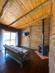 a room with a bed and a fireplace in a cabin at Mirador de Montaña in Ciudad Lujan de Cuyo