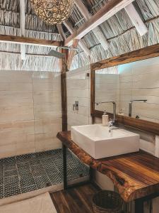 uma casa de banho com um lavatório branco e um espelho. em Monoloko Lodge Popoyo em El Limón