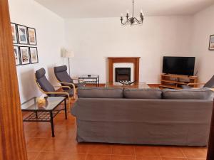 ein Wohnzimmer mit einem Sofa und einem Tisch in der Unterkunft Villa Georgiana - 4 Bed Property with private pool in Playa Blanca