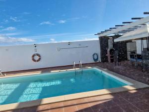 ein Schwimmbad in der Mitte eines Hauses in der Unterkunft Villa Georgiana - 4 Bed Property with private pool in Playa Blanca