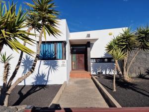 ein weißes Haus mit Palmen davor in der Unterkunft Villa Georgiana - 4 Bed Property with private pool in Playa Blanca