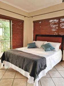 a bedroom with a large bed with two pillows on it at La Casa Greeff Guesthouse in Pretoria