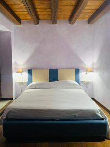 uma cama num quarto com duas lâmpadas na parede em WUNDERGARTEN Rural Spa House em Gratteri