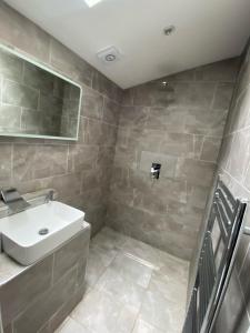 a bathroom with a white sink and a mirror at Large king-size bedroom with modern fitted kitchen in Greater London in Eltham