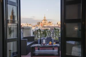a table with a bowl of fruit on a balcony at Hotel Plaza in Seville
