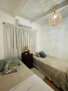 una camera con due letti e un lampadario a braccio di Cabaña La América a Ezeiza