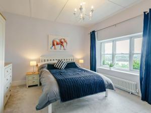 a bedroom with a bed and a chandelier and windows at Spire View in Wilton