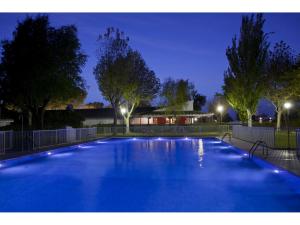 a large blue swimming pool at night at Parador de Albacete in Albacete