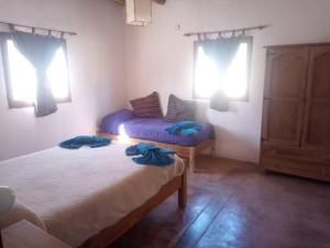 a bedroom with two beds in a room with windows at El Sueñero in Tilcara