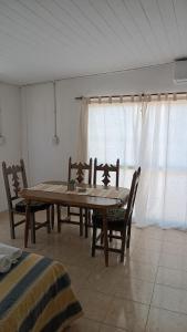 Un comedor con mesa y sillas y una ventana. en Laprida, en Curuzú Cuatiá
