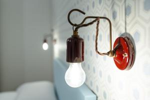 a red and white light hanging on a wall at La Dimora del Principe in Bagnoregio