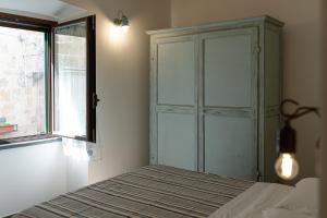 a bedroom with a bed and a window and a cabinet at La Dimora del Principe in Bagnoregio +19 photos
