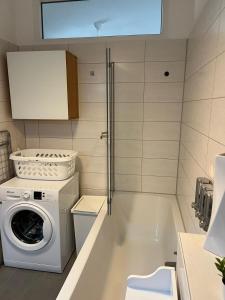 a laundry room with a washing machine and a washer at Schmuckstück im Herzen Rostocks mit grüner Oase in Rostock
