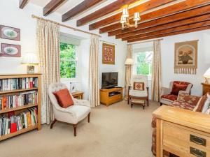 a living room with a book shelf and a tv at Corner House in Grinton